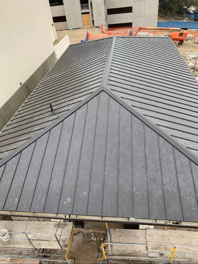 Commercial metal roof construction with crane equipment in Macomb